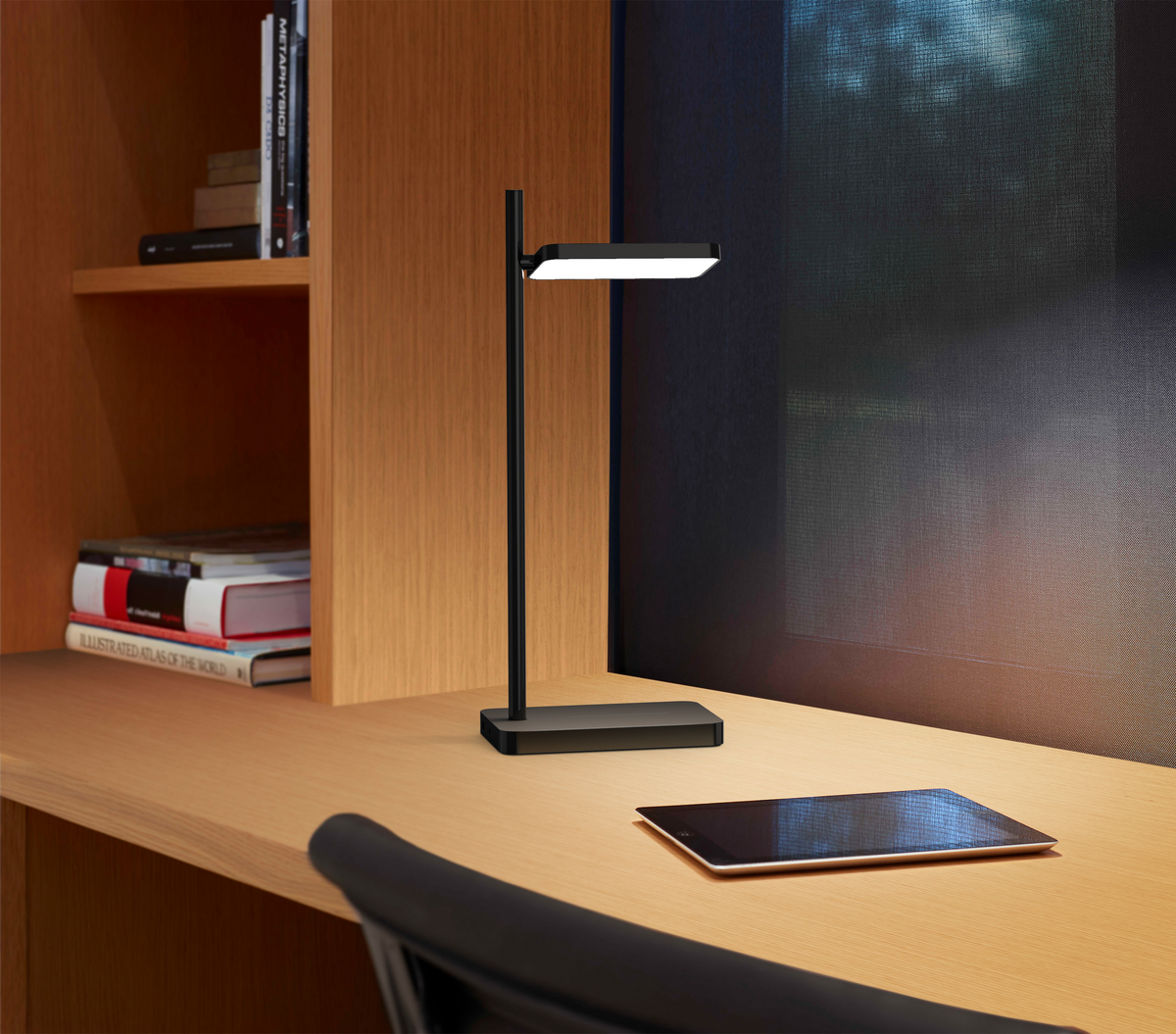 Talia desk lamp charging a phone on a home office desk