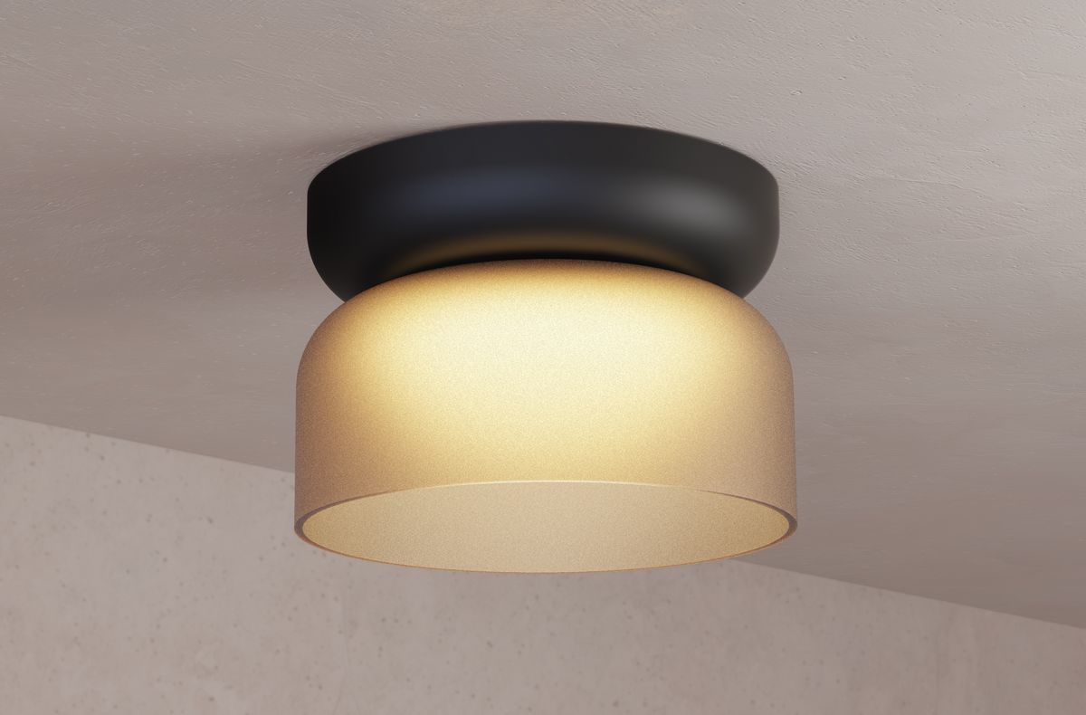 Black-canopy mini glass flush mount with amber glow on a beige ceiling, in-situ photo