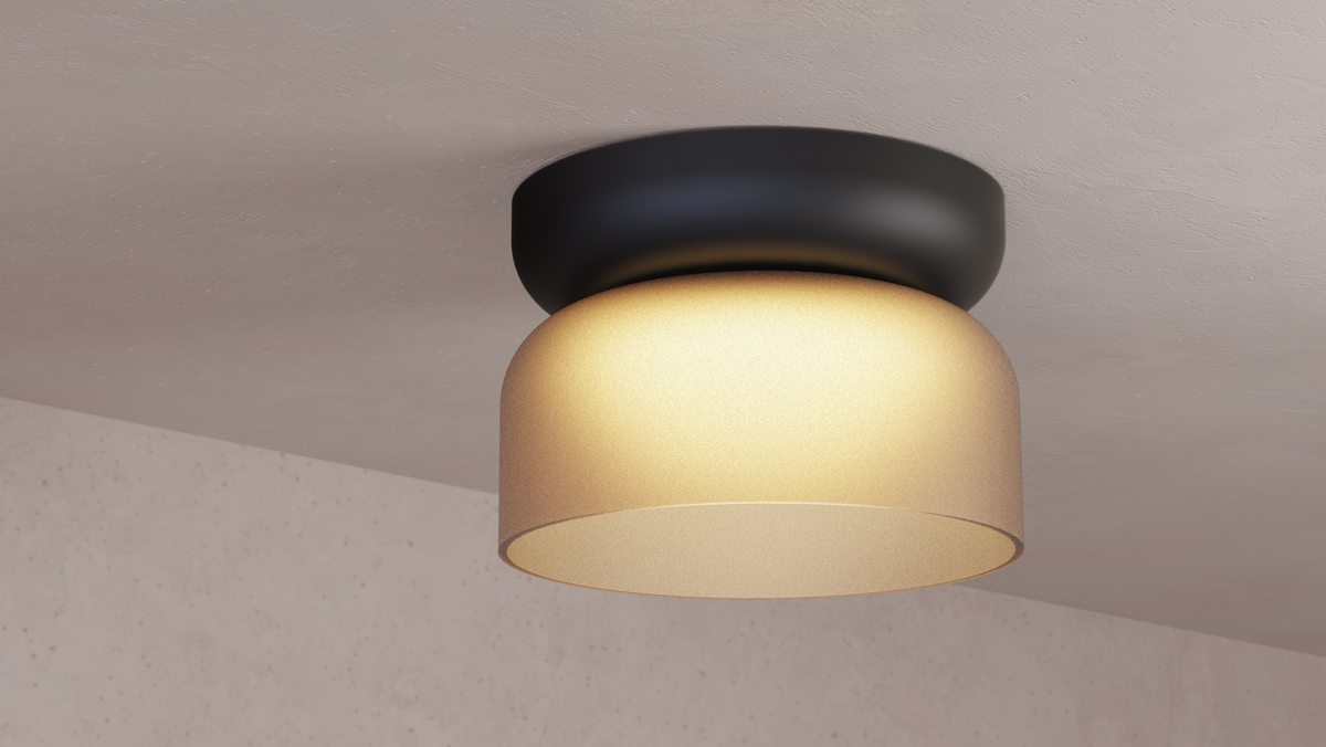 Small flush mount with warm etched amber glass glowing against a sloped ceiling