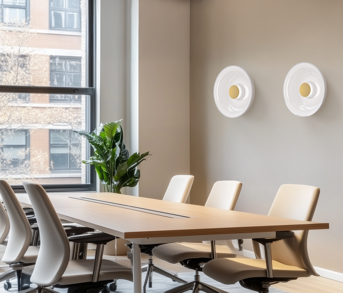 Two opal glass sconces on a wall above a meeting room table with task chairs