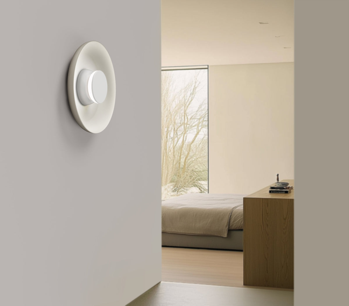 Spun metal Totem sconce lighting a hallway wall