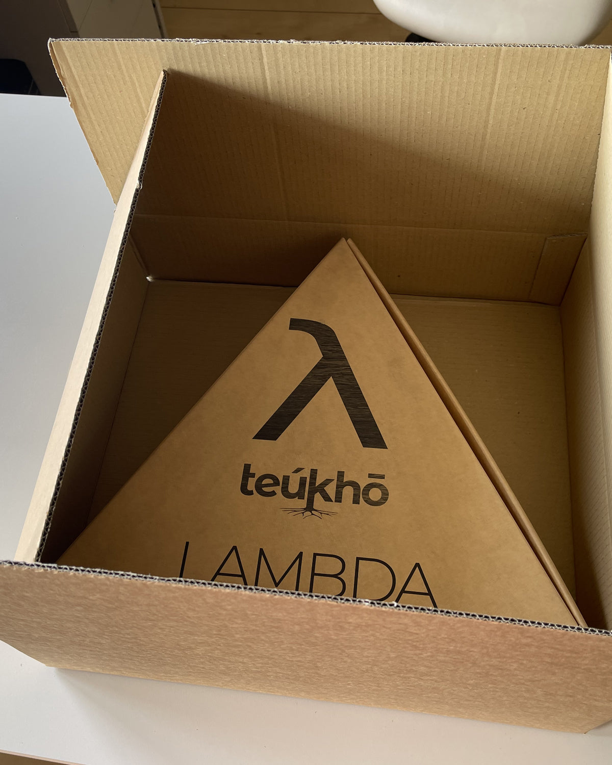 Teukho Lambda fossil oak LED table lamp open shipping box with the triangular λ gift box