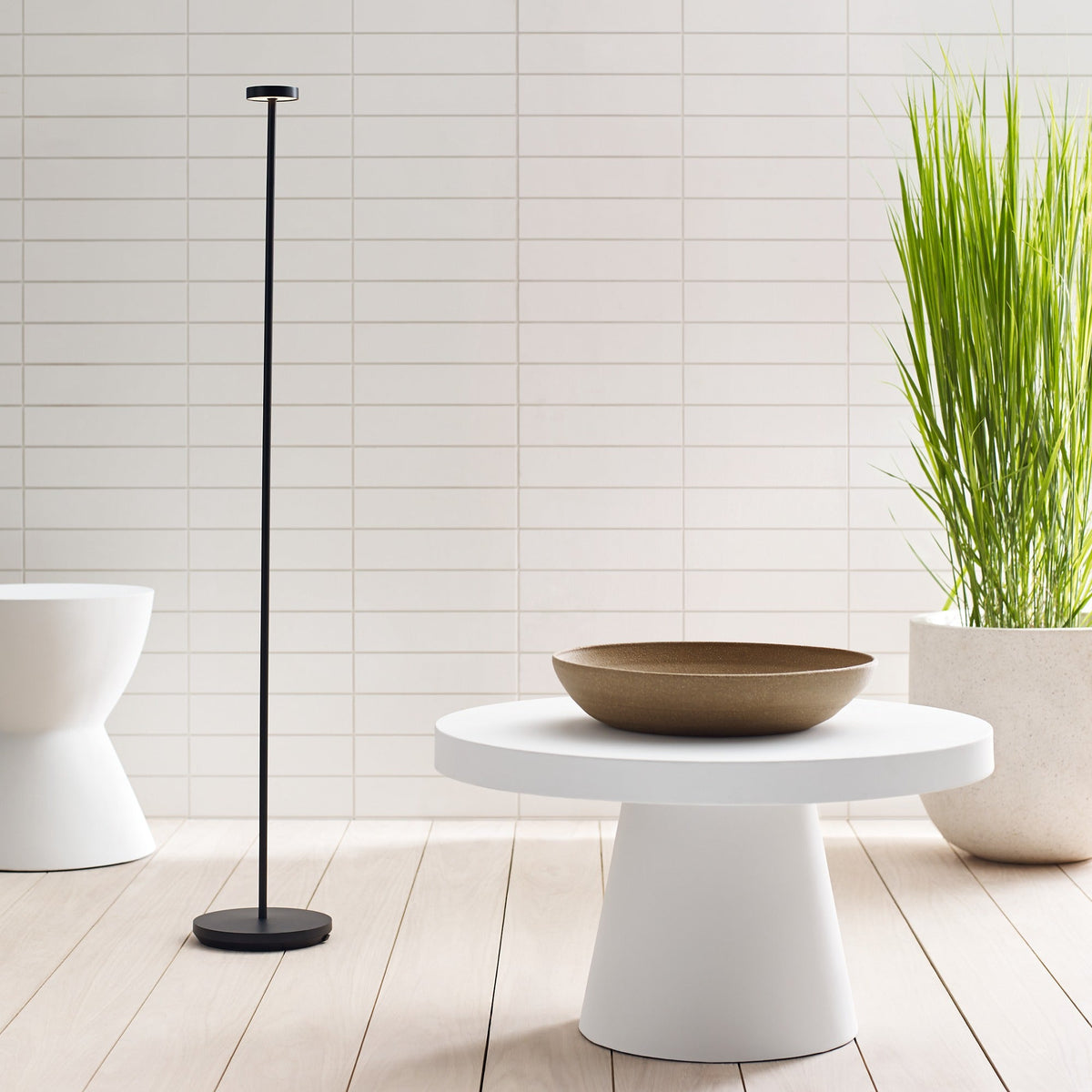 Moneta Medium cordless floor lamp in Black glowing in a room