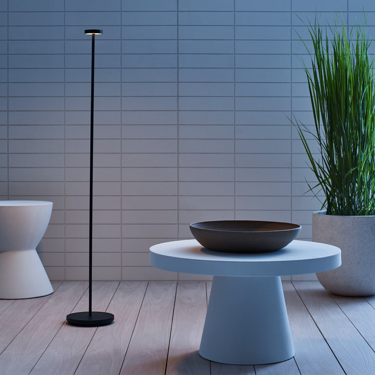 Moneta Medium floor lamp glowing at dusk