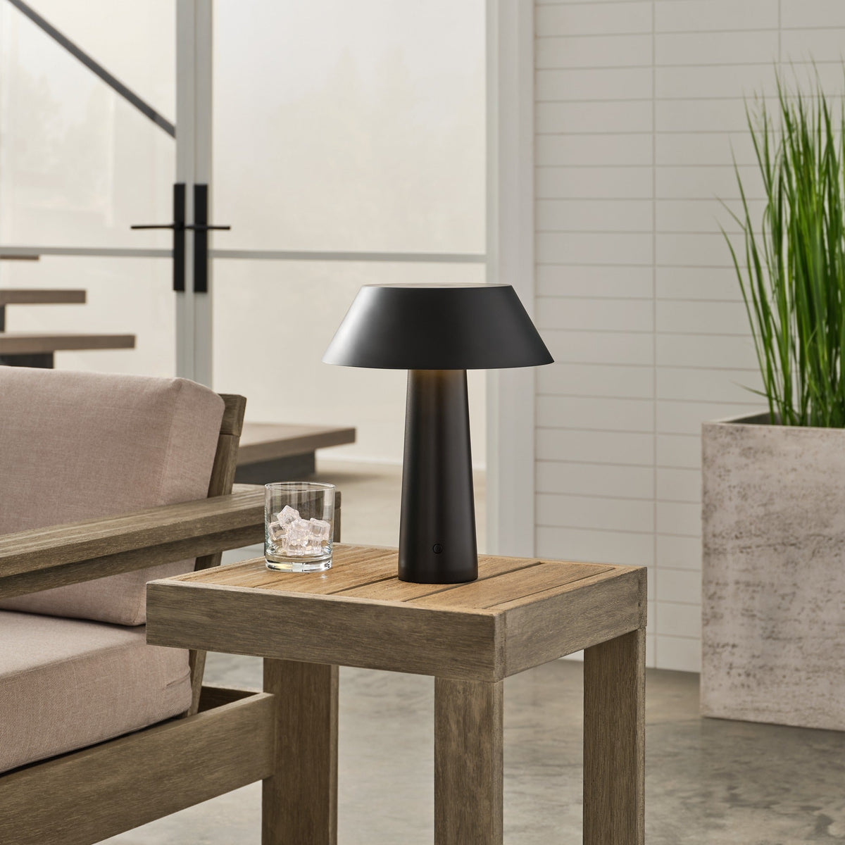 Sesa Accent cordless table lamp in Black glowing on a table