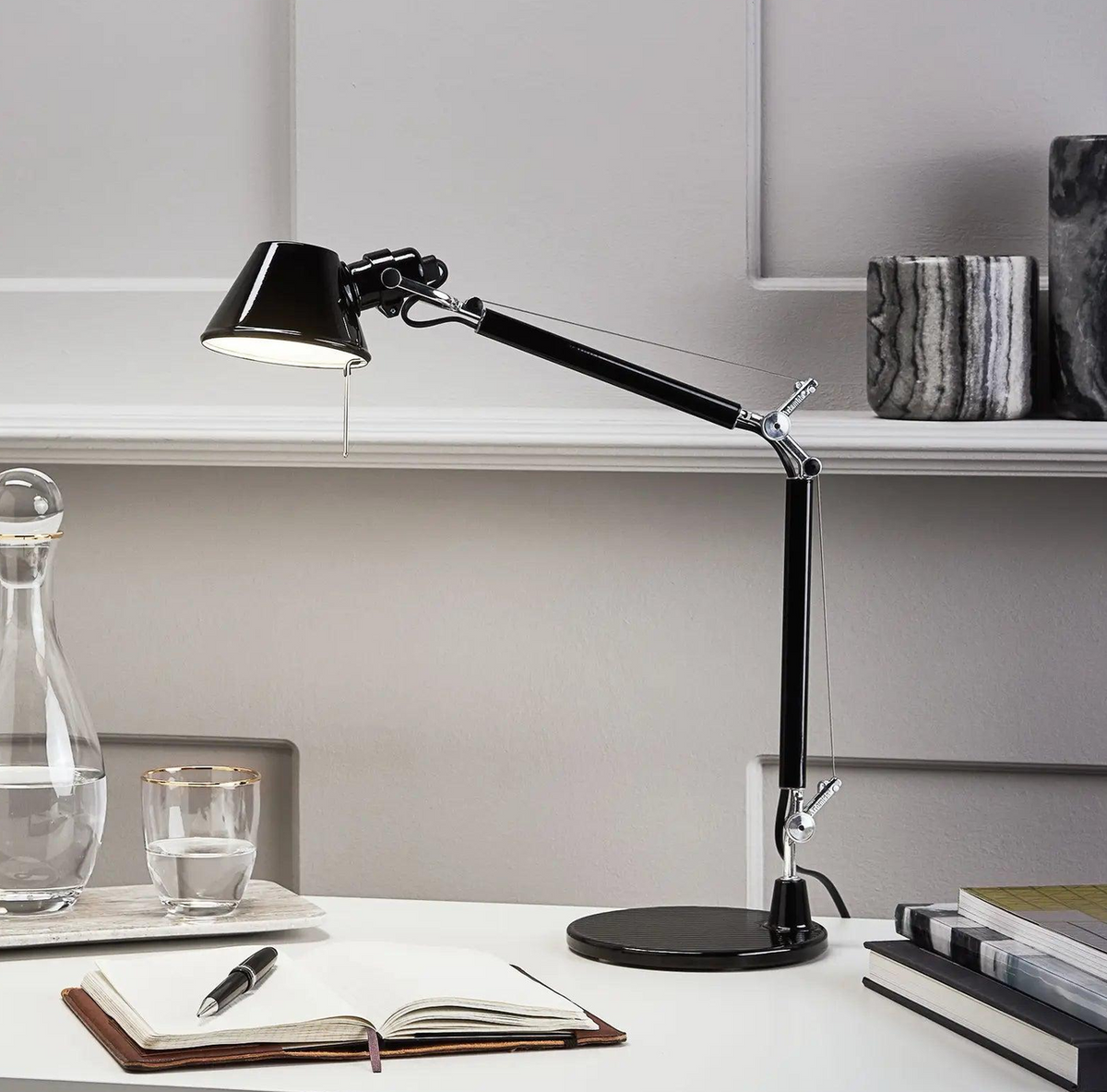 Tolomeo Micro black table lamp positioned on a contemporary writing desk