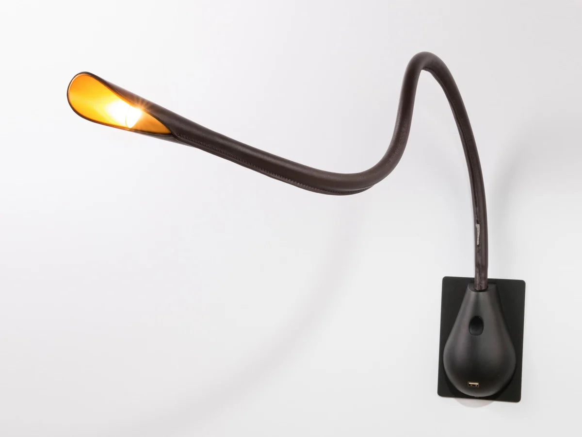 Modern Innermost Cobra wall sconce in rich brown leather, highlighting the black semi-gloss switch box.