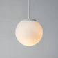 Frosted glass globe pendant light with white steel cap, perfect for minimalist modern living rooms.