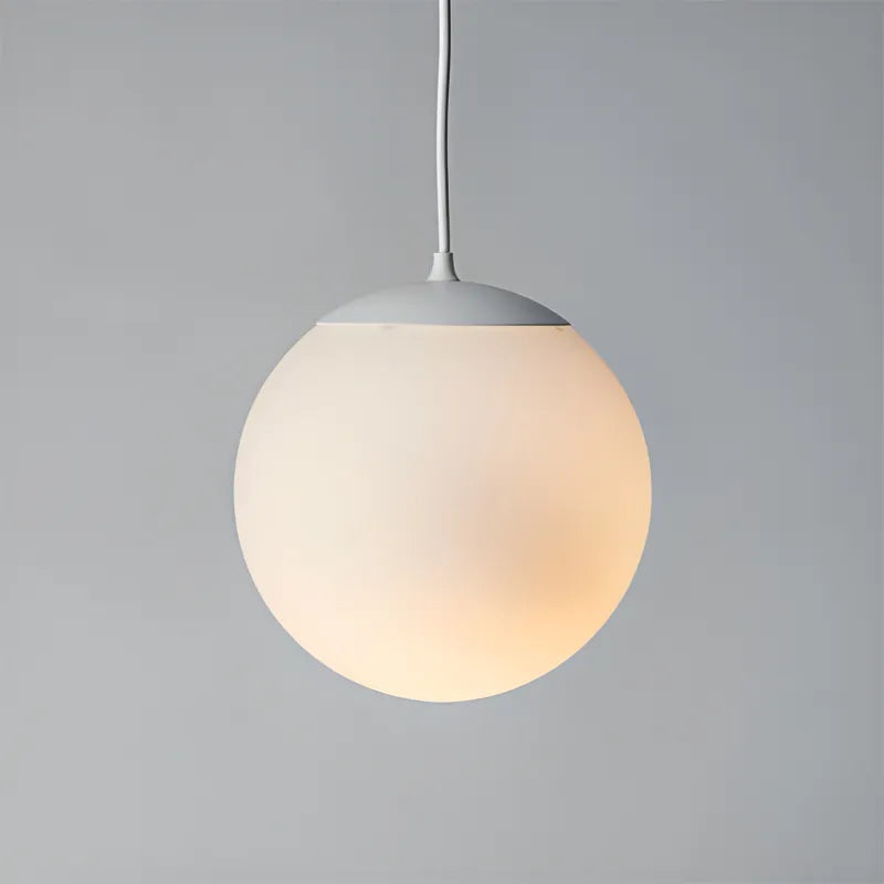 Frosted glass globe pendant light with white steel cap, perfect for minimalist modern living rooms.