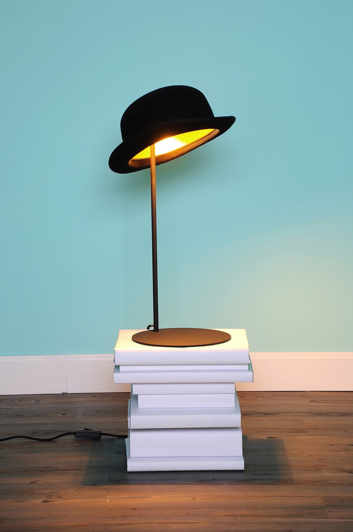 Innermost Jeeves table lamp by Jake Phipps – on a stack of books