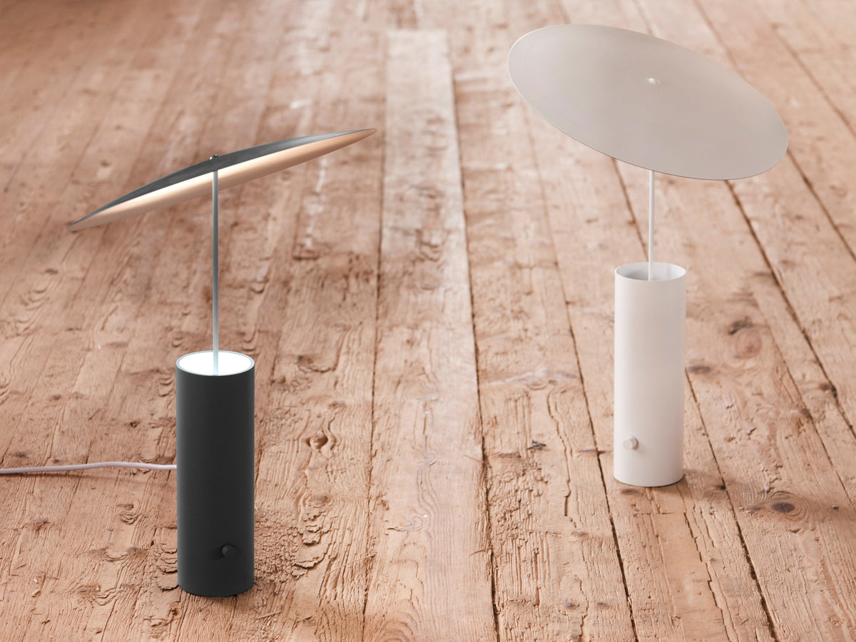 Innermost Parasol LED table lamp by Jonas Forsman – the black and white versions on a wood floor