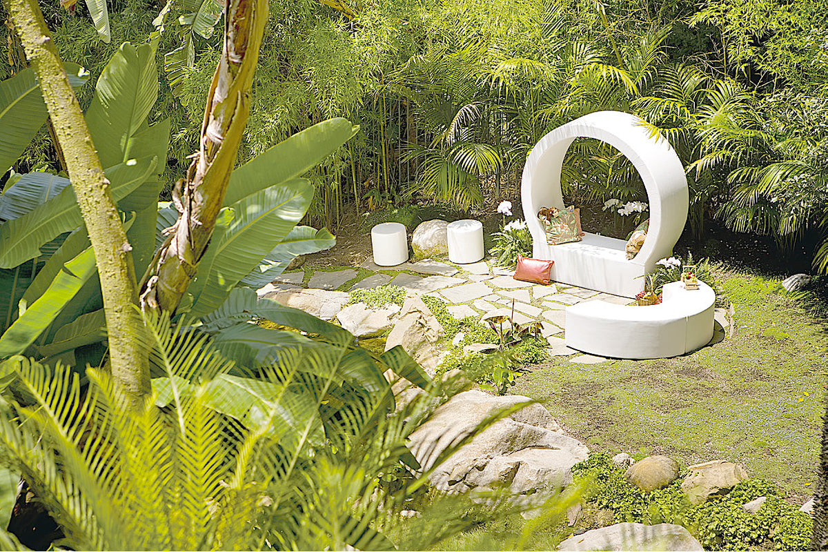 White Arc and Dot seating around a round moon-gate seat in a tropical garden