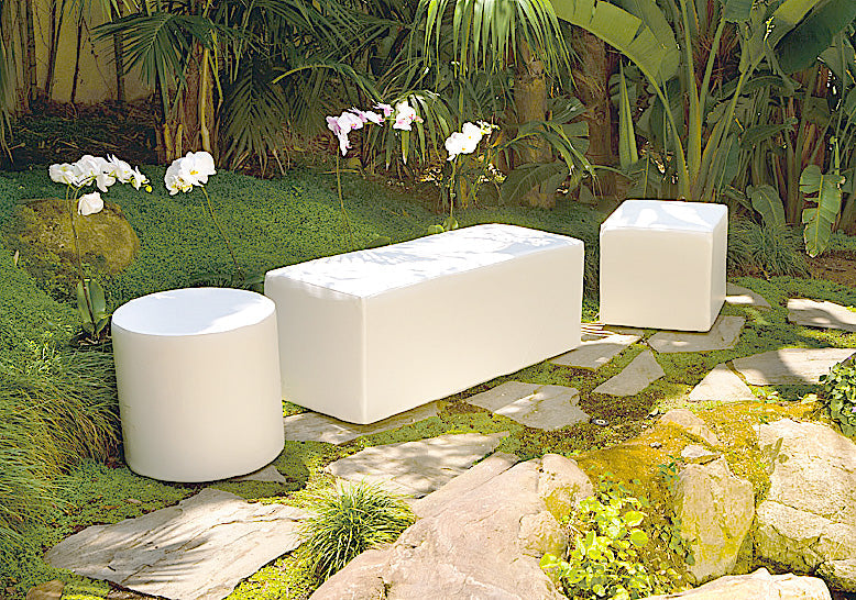White Dash bench and Dot cylinder ottoman on stone steps in a tropical garden with orchids