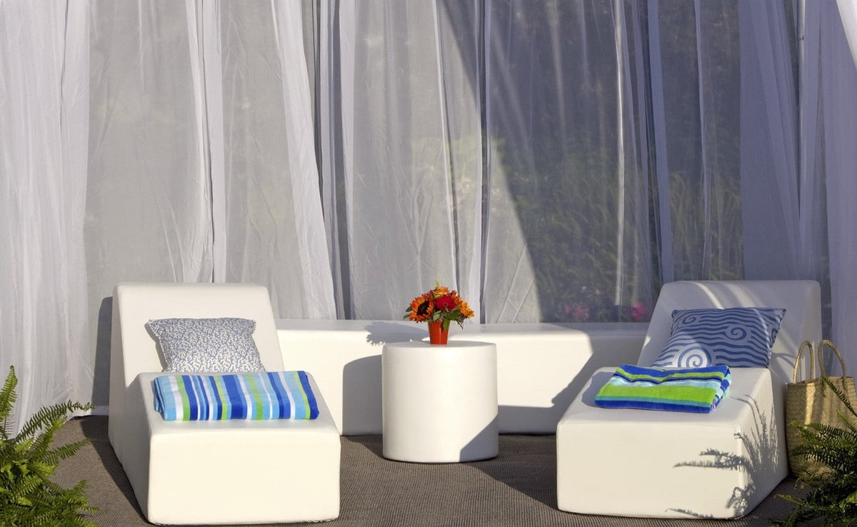 Pool Club Now cabana set in white vinyl: two chaise lounges, benches and a round ottoman with striped pillows under sheer curtains