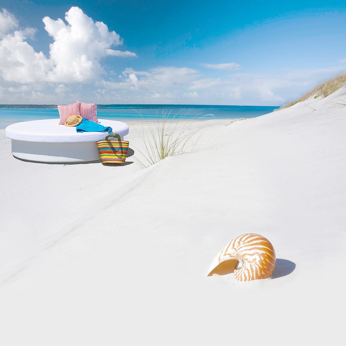White 78-inch round La Fête Sun Pad daybed on a clean white sand backdrop