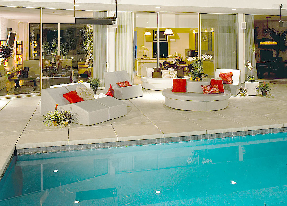 Round Sun Pad with a Stack drum and modular white seating on a pool deck at dusk