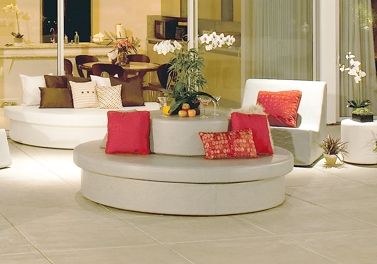 Round Sun Pad with red pillows forming a conversation area with white modular seating on a patio