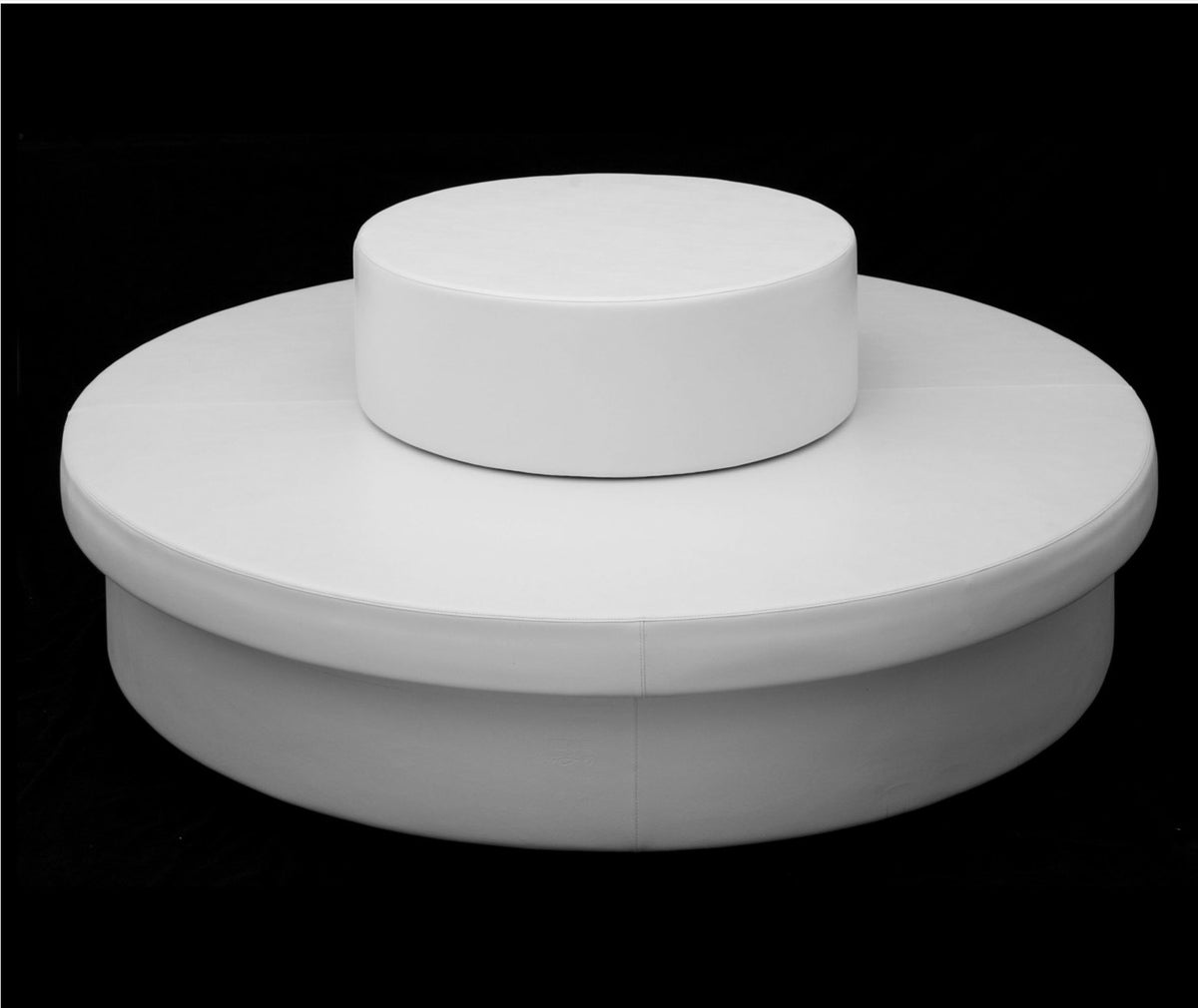 Studio view of a white Stack drum centered on a round Sun Pad against a black backdrop