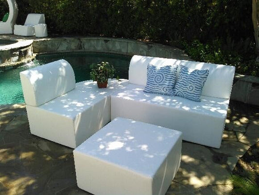 Zinc 30-inch square ottoman in white marine vinyl used as a low table in front of a Zig Duo bench and Zig chair, poolside