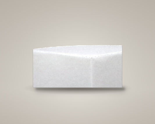 Zest corner ottoman in white vinyl on a soft warm-grey studio backdrop with a floor shadow, angled view