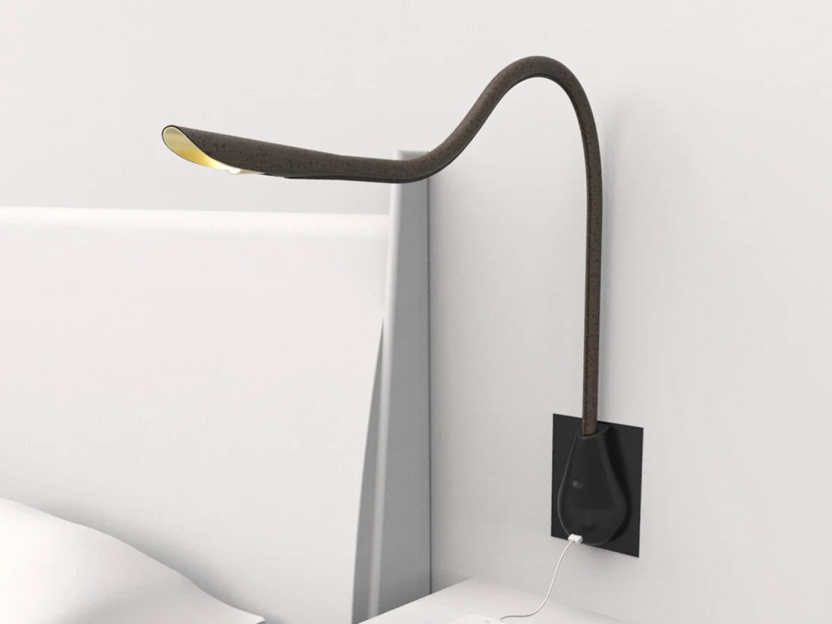 Directional brown leather Cobra wall light by Innermost, featuring a movable arm and gold interior for focused illumination.