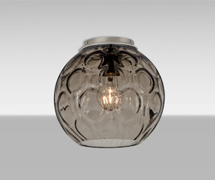 Besa Bombay Smoke globe lit, filament glowing through the optic pattern