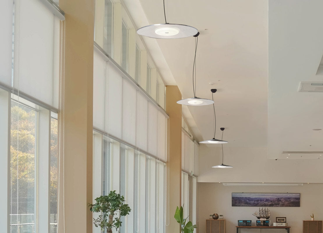 Besa Swan disc pendant on a cable: hung over a long corridor window wall