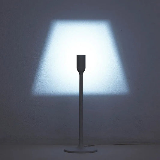 Yoy Table Lamp by Innermost projecting a classic lampshade illusion onto a white wall in a modern living room.